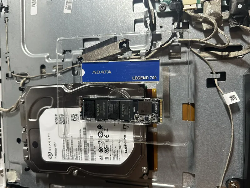 Unidad SSD junto al disco duro mecánico dentro de una computadora abierta