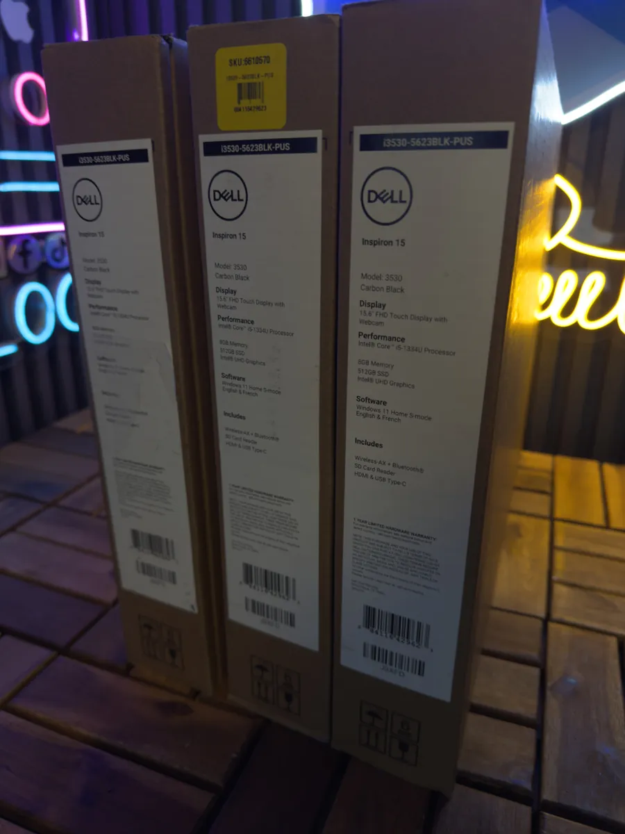 Tres cajas de laptops nuevas con su etiqueta de características